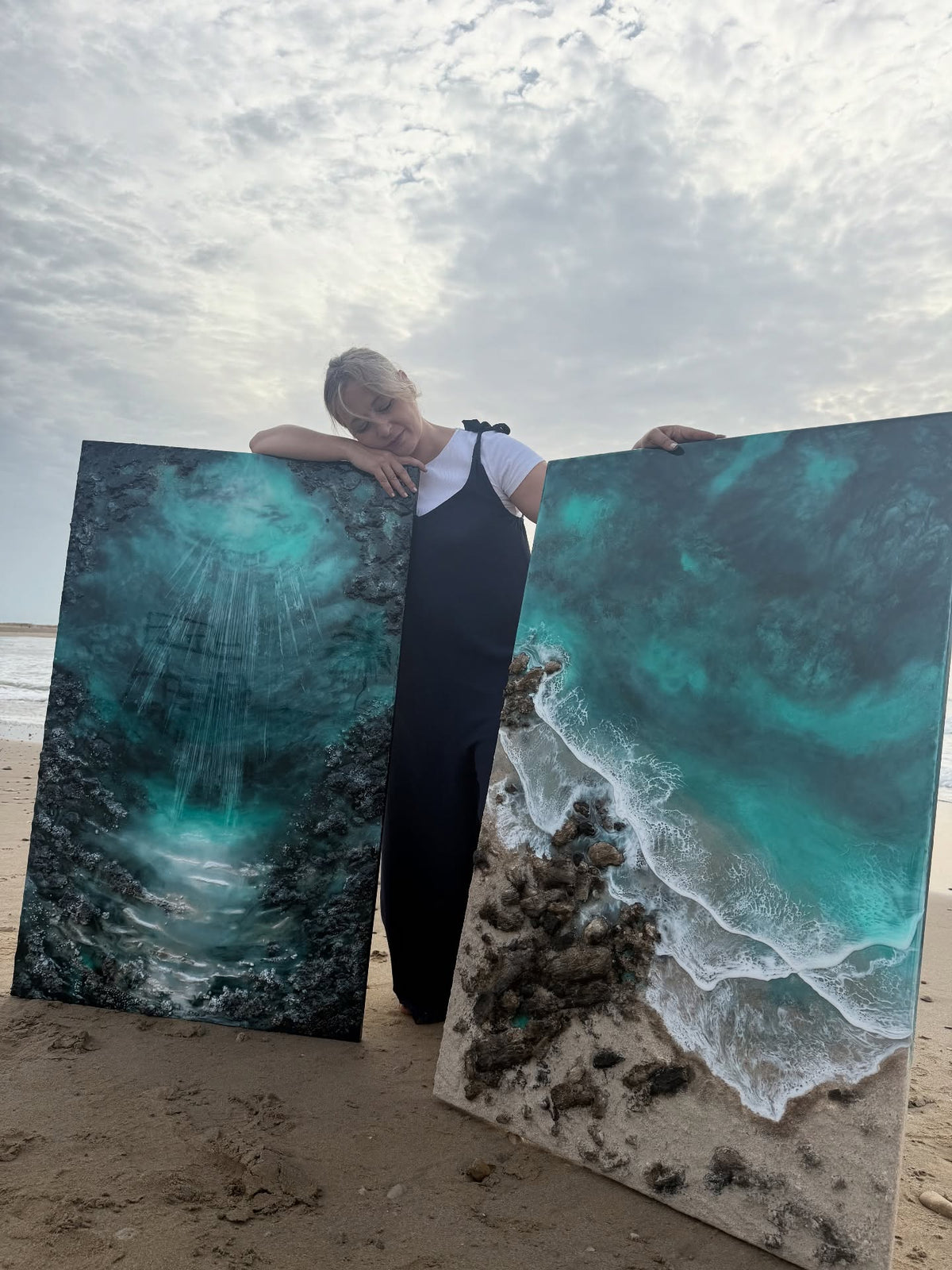 Eva Jurado en la playa, entre dos de sus obras